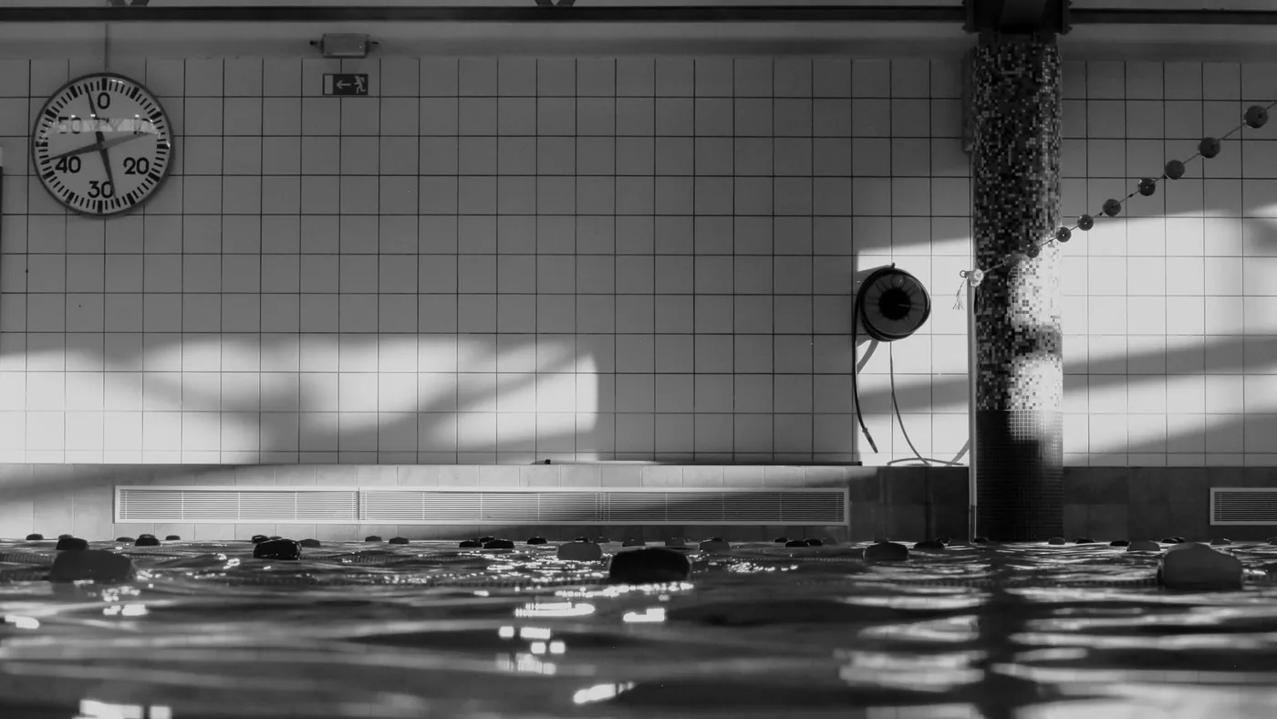 Hallenbad in Schwarzweiss mit Spiegelung auf der Wasseroberfläche