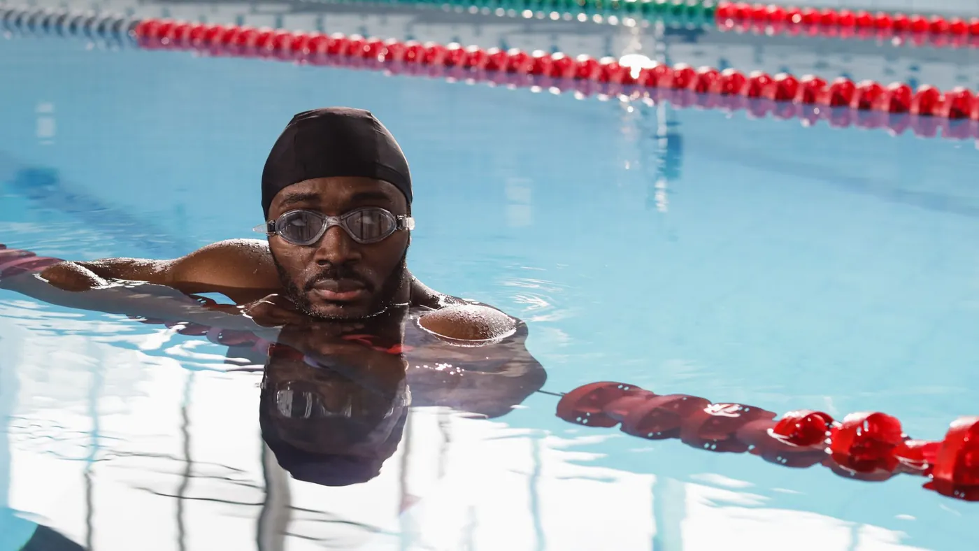 Schwimmer zieht seine Bahn im leeren Hallenbad