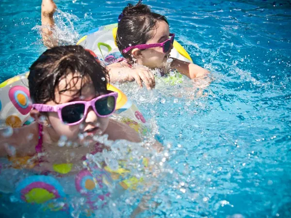 Kinder mit Schwimmhilfen im Wasser
